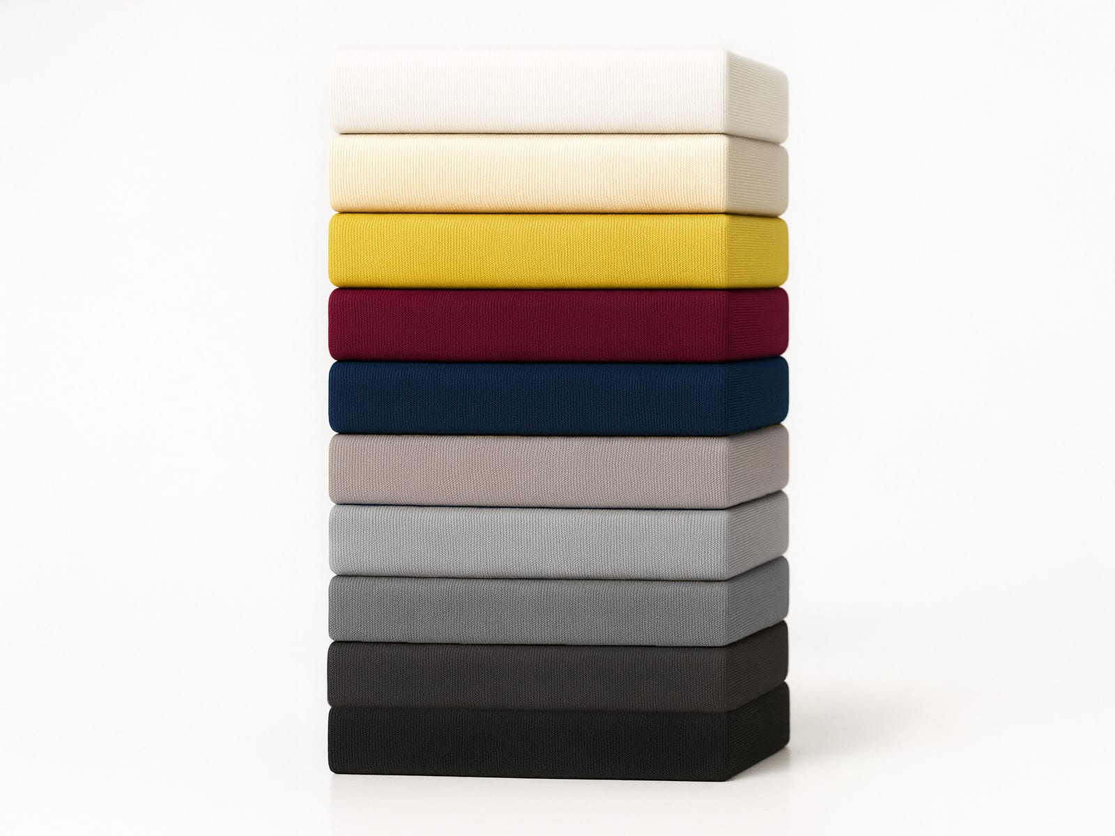 Stapel aus zehn farbigen Spannbettlaken in Weiß, Creme, Gelb, Rot, Blau, Grau und Schwarz